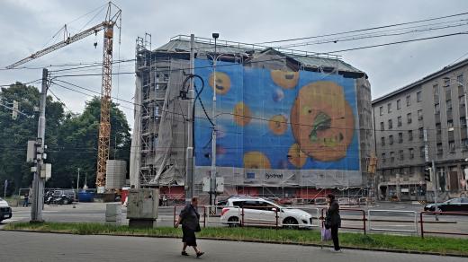 Jedna z budov obchodního domu pod lešením a plachtou