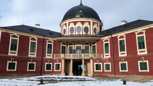 Střední část zámku Veltrusy právě prochází opravou. Za okny můžete zahlédnout žebříky a lešení. Pohled na barokní zámek z parku je ale stále krásný