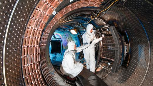 Dva technici provádějící údržbu wolframového prostředí v tokamaku v ustáleném stavu v Cadarache ve Francii