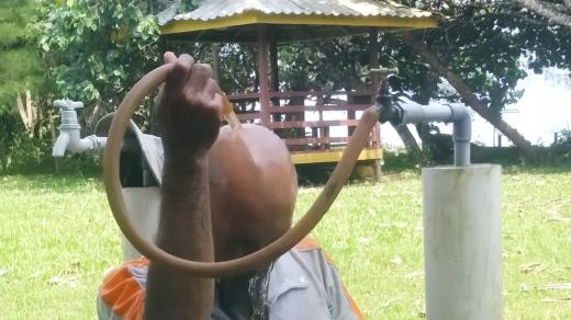 Jeden ze strážců parku se hned ráno chladí pod studenou hadicí s vodou