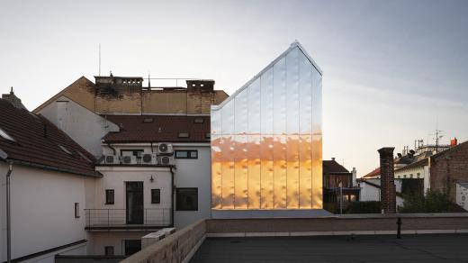 Téměř zrcadlová fasáda přístavby odráží okolní svět