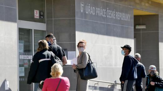 Fronta lidí v rouškách a bezpečnostních rozestupech před úřadem práce