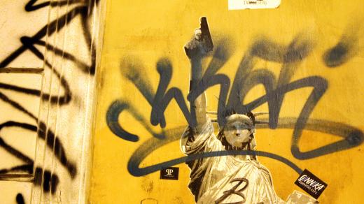 Socha svobody s pistolí a graffiti
