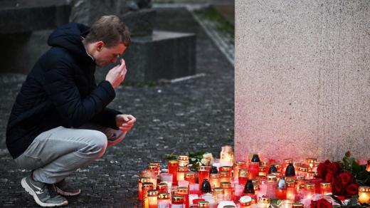 Lidé pokládají svíčky před sídlem Karlovy univerzity