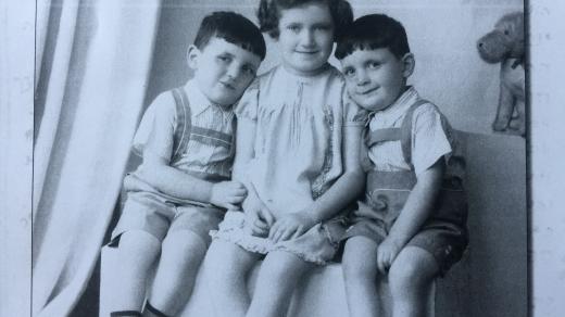 Dvojčata Jiří a Josef Fišerovi se svou starší sestrou Věrou. Snímek pochází z roku 1938. Věra později zahynula v plynové komoře, stejně jako matka dětí. Věře bylo tehdy 10 let.